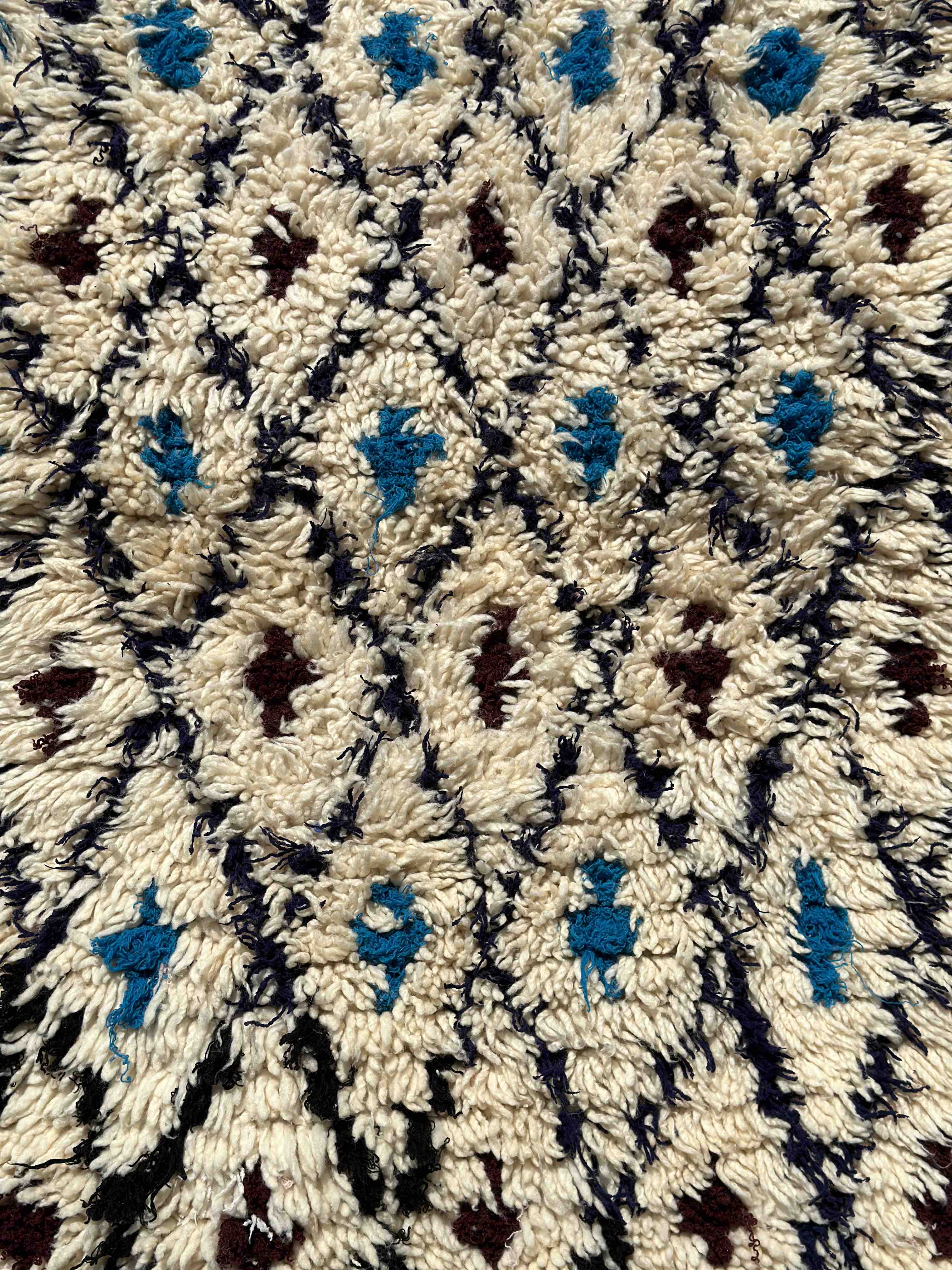 Beni Ouarain Marrokansk tæppe hvide, sorte, blå og brune nuancer.