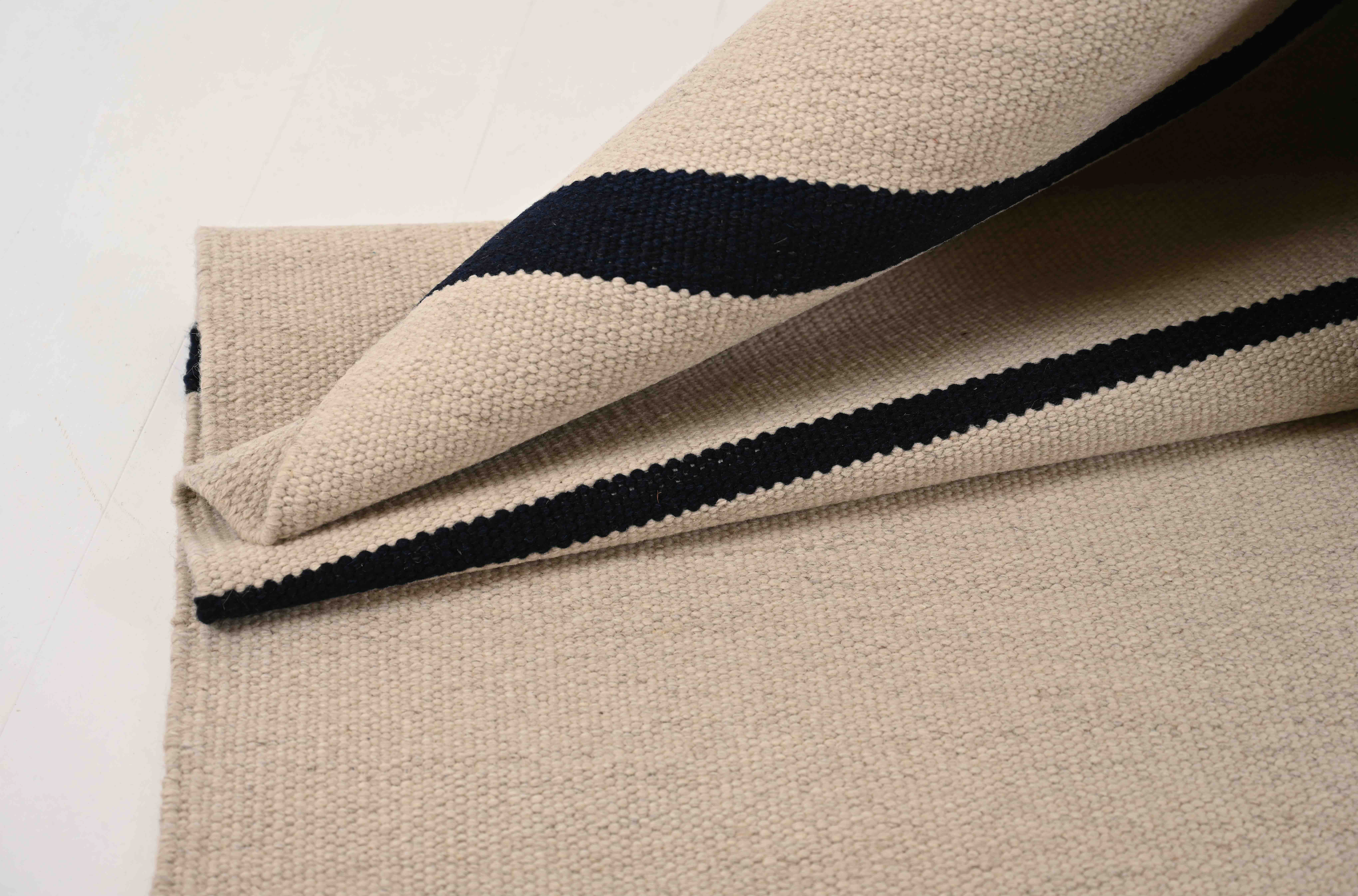 Sandfarvet uldtæppe med navyblå striber – Copenhagen Classic Kollektion