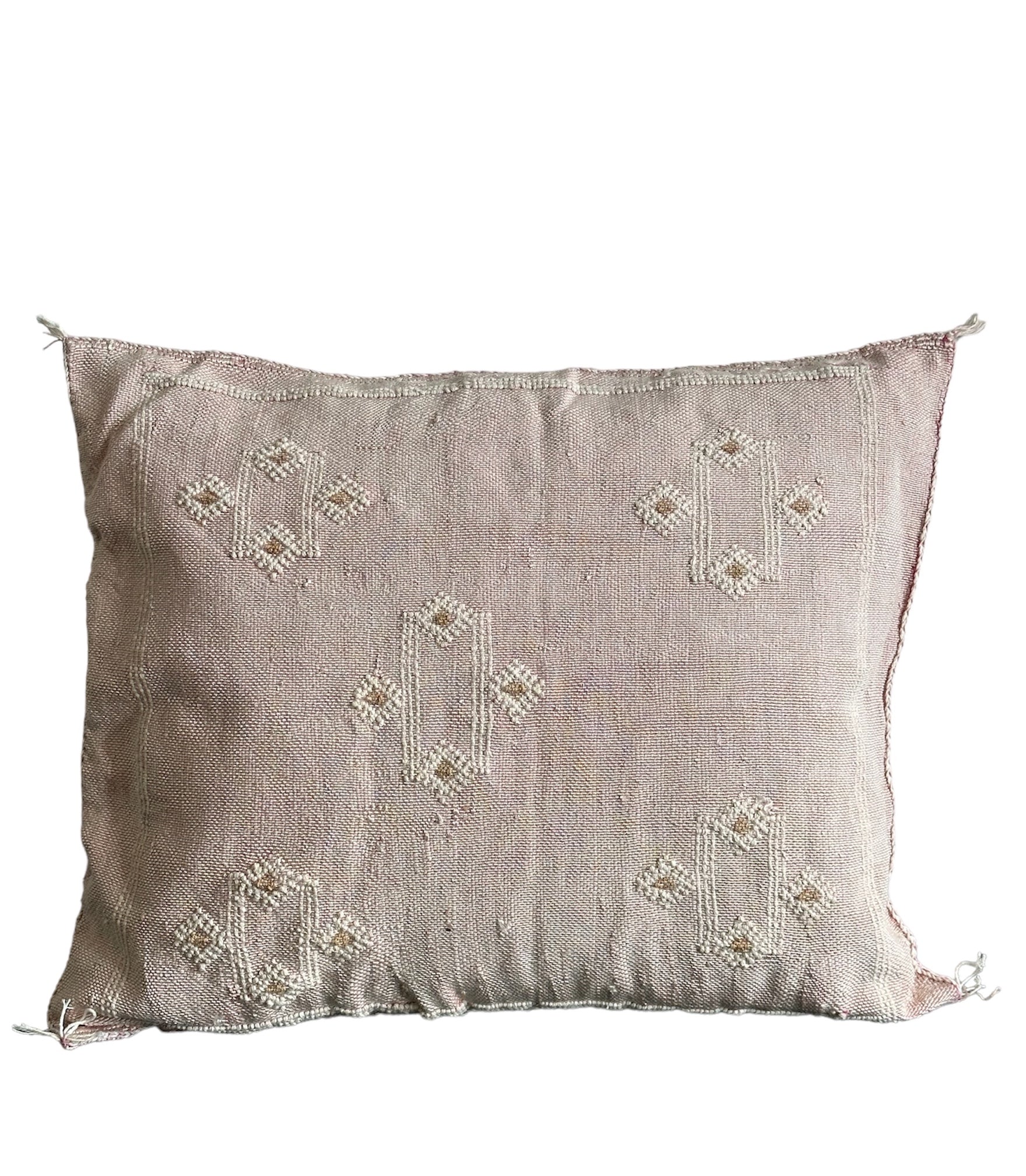 Lyserød bamuldspude med hvid mønster.