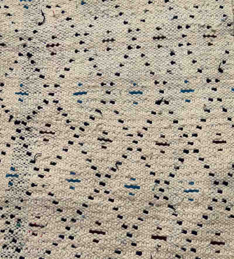 Beni Ouarain Marrokansk tæppe hvide, sorte, blå og brune nuancer.